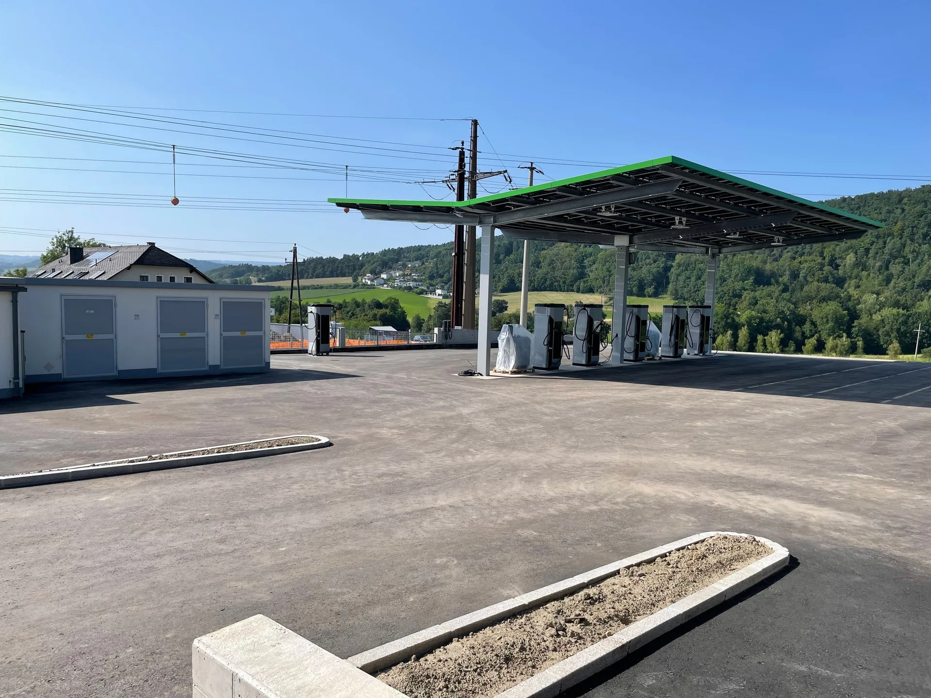 Bauphase: frisch asphaltierter Platz, die Säulen unter dem Vordach noch verpackt