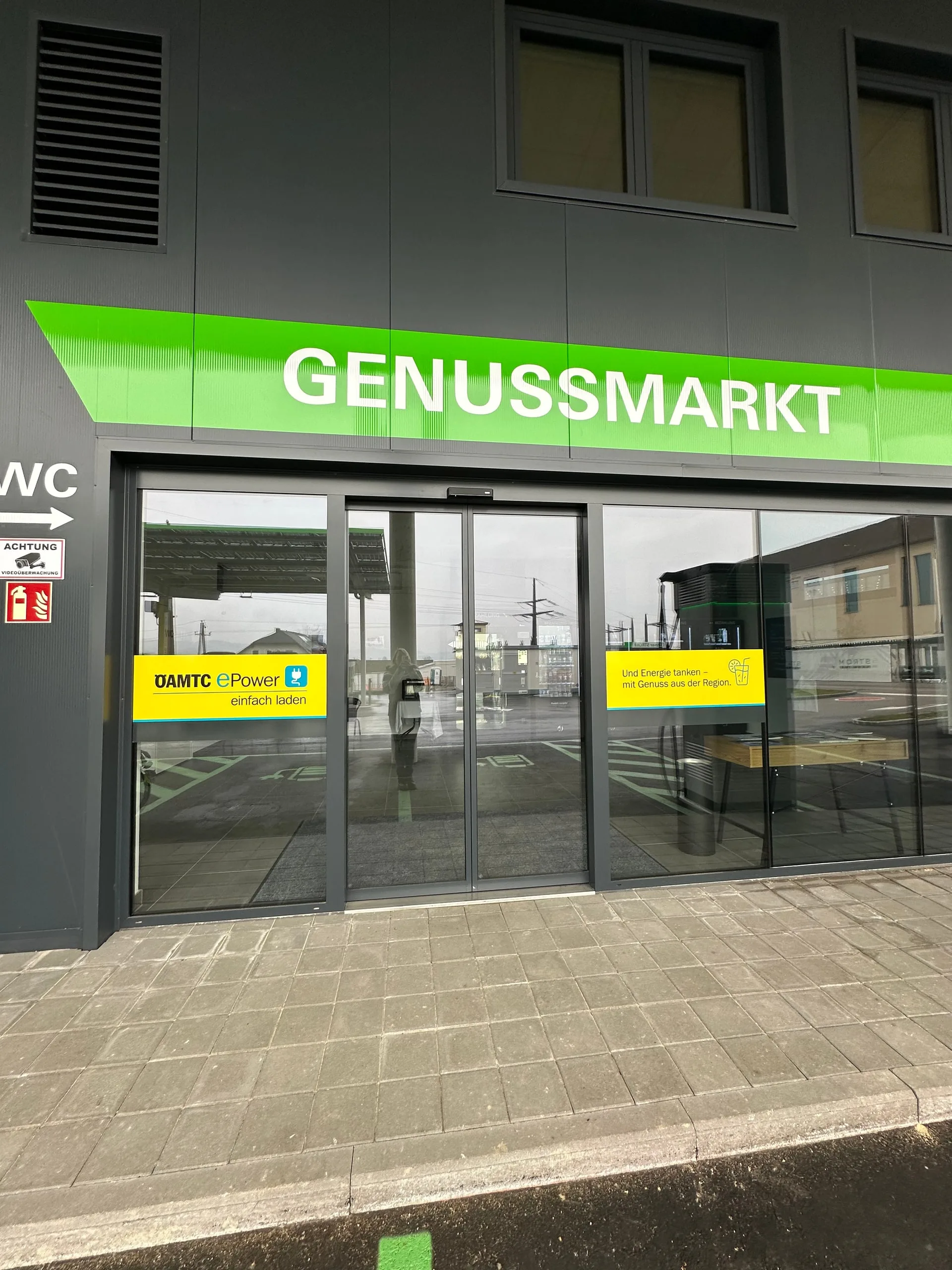 Glastür unter dem Schriftzug Genussmarkt, daneben der Hinweis auf das WC