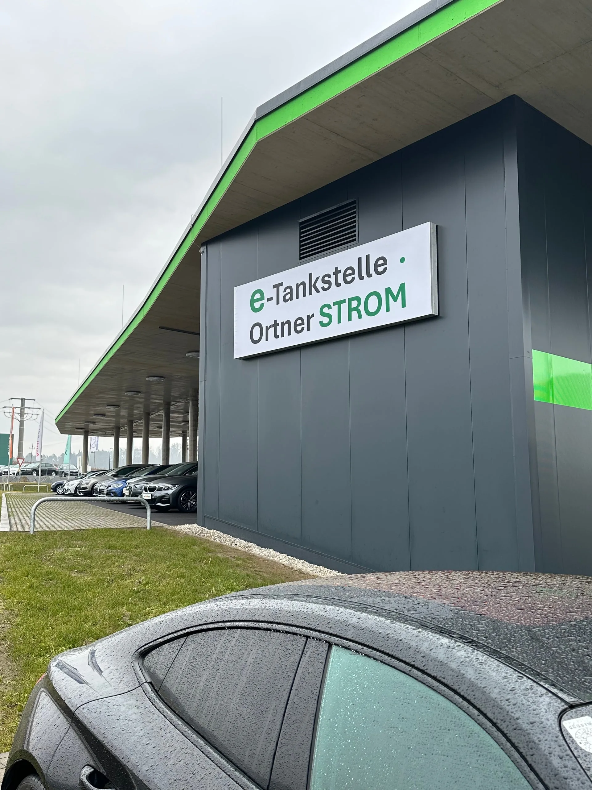 Gebäudeseite mit dem Schild e-Tankstelle Ortner Strom