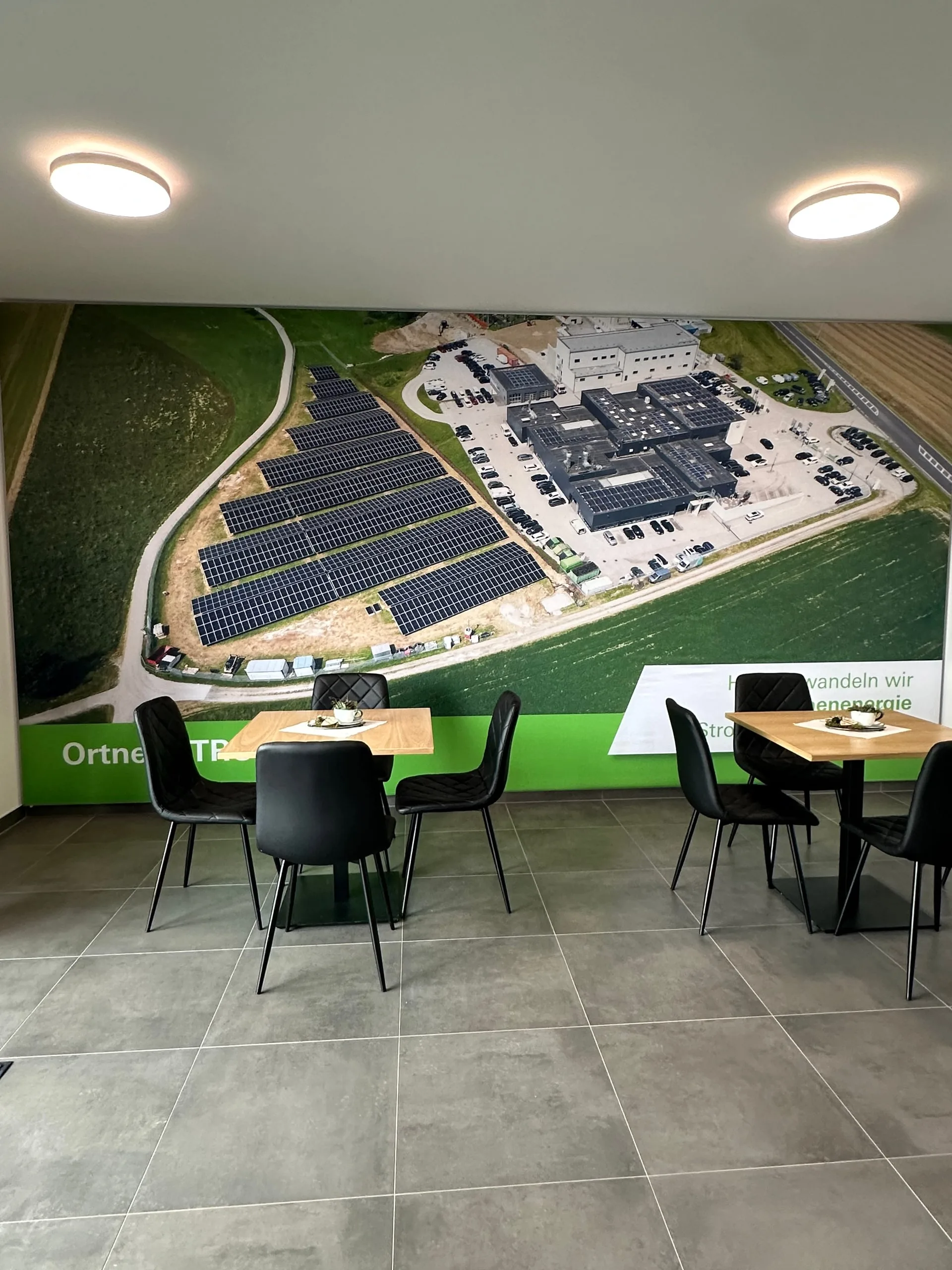 Wandbild in der Lounge: die Photovoltaik-Freiflächenanlage und der Ladepark von oben